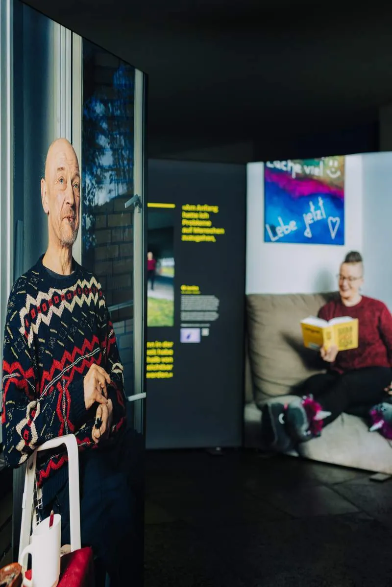 Leuchtkästen mit Porträts eines Mannes im Strickpullover und einer lesenden Frau, HOME STREET HOME
