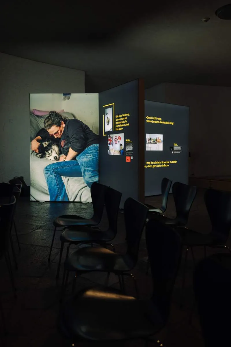 Leuchtkasten mit dem Porträt eines Mannes mit Hund in der abgedunkelten Ausstellung